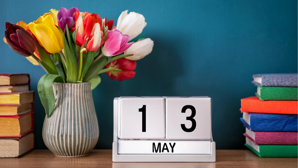 flip calendar displaying May 13 beside a vase of tulips