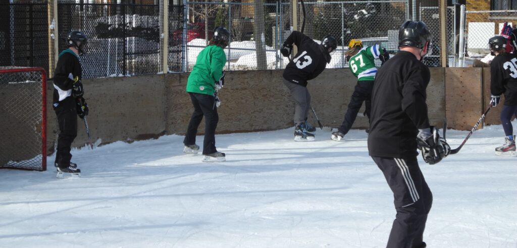 players from opposing teams hustling for puck along the boards