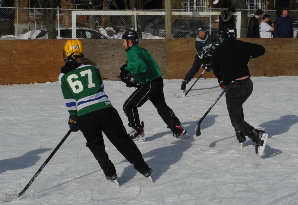 players from opposing teams skating to puck