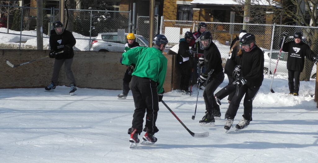 players from opposing teams skating to puck