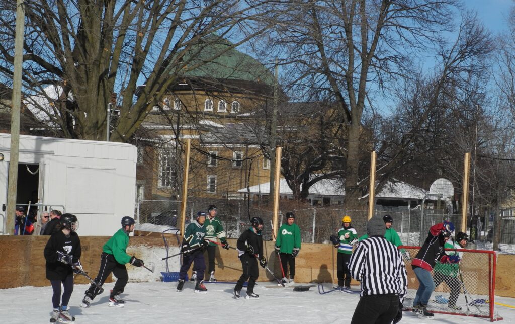 wide angle view of Mutchmore Rink and 2 teams fighting for puck