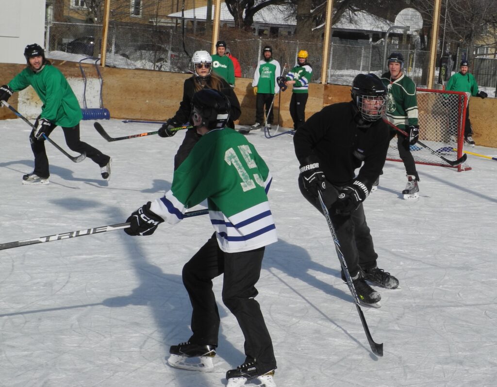 opposing teams rushing to get possession of loose puck